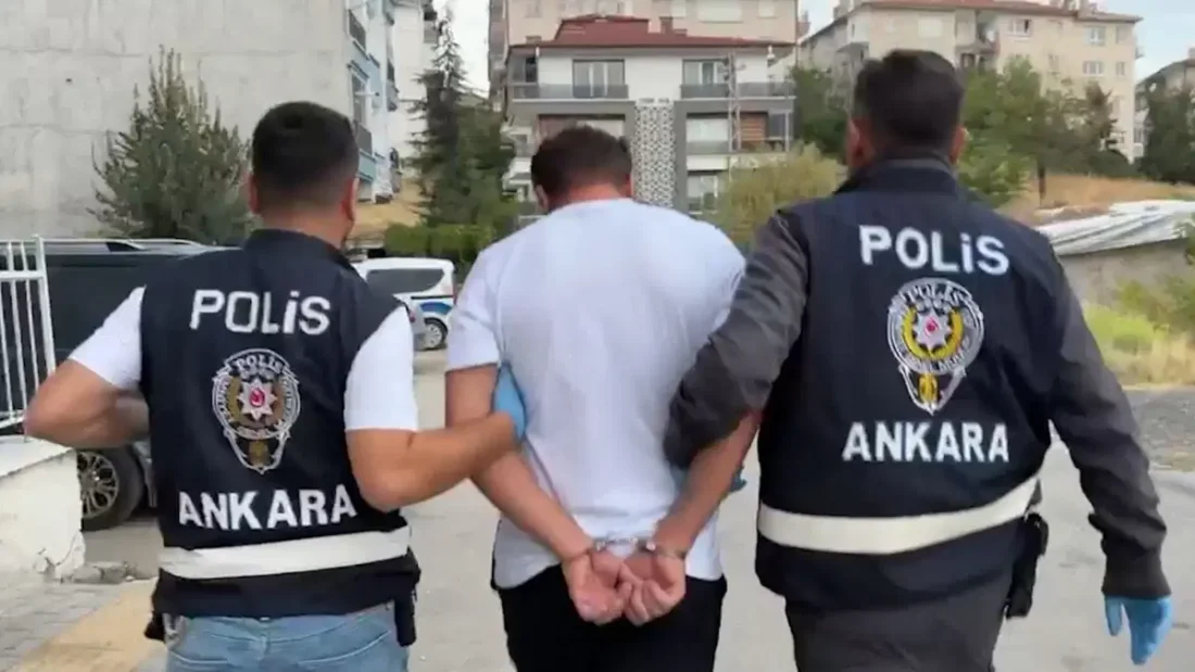 İki polis memurunun gözaltına aldığı bir şüpheliyi kelepçeli şekilde götürmesi