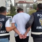 İki polis memurunun gözaltına aldığı bir şüpheliyi kelepçeli şekilde götürmesi